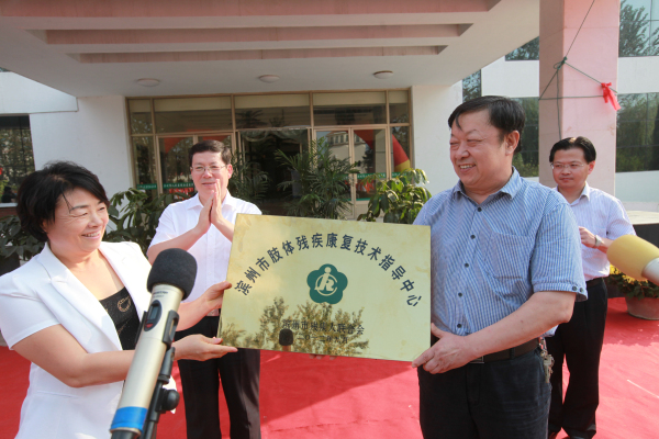 我院党委书记、院长王树德接受市残联理事长王悦华授牌.jpg